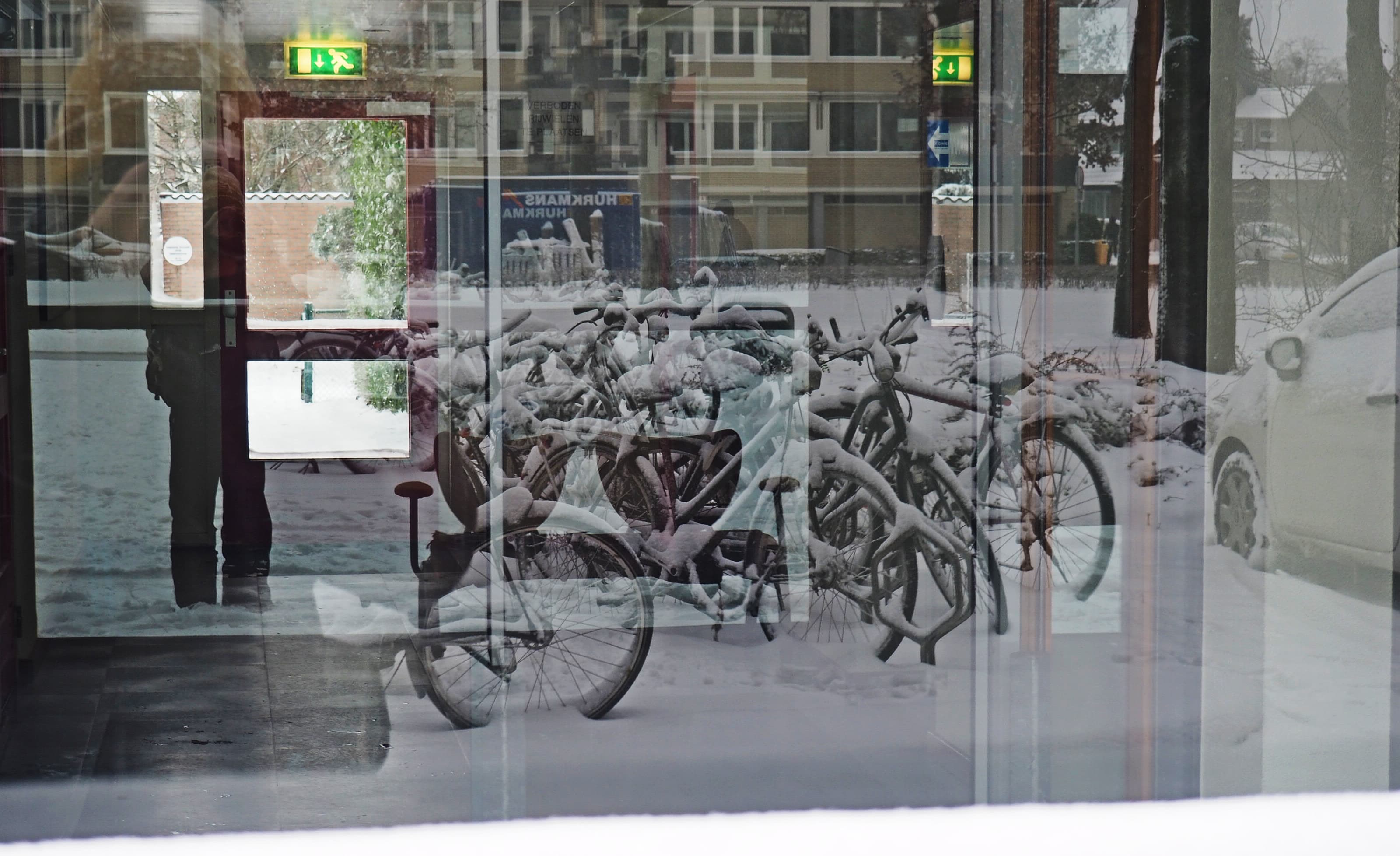 Snow-Buried Bicycles Behind Glass